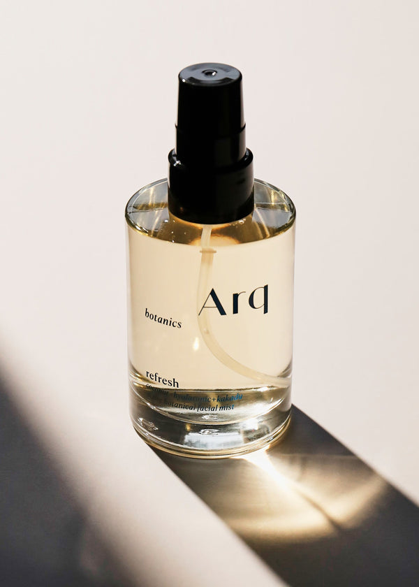 A bottle of arq perfume elegantly placed on a table, showcasing its refined design and captivating fragrance.